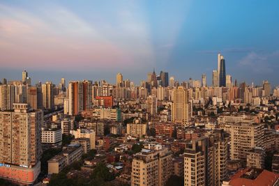 Aerial view of buildings in city against sky