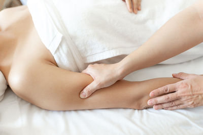 Midsection of woman lying on bed