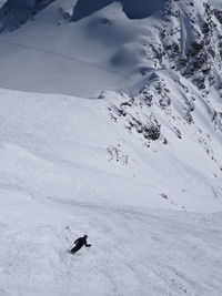 Rear view of person skiing on snowcapped mountain