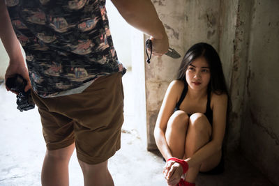 Hopeless woman sitting by wall