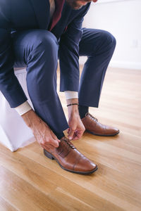 Low section of man standing on hardwood floor