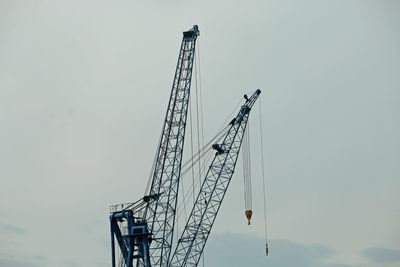 Low angle view of crane against sky