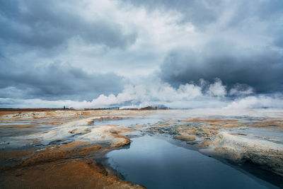 Scenic view of volcanic water against cloudy sky