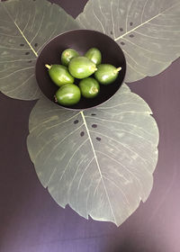 High angle view of green fruits and leaves on table