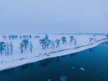 Scenic view of lake against blue sky during winter