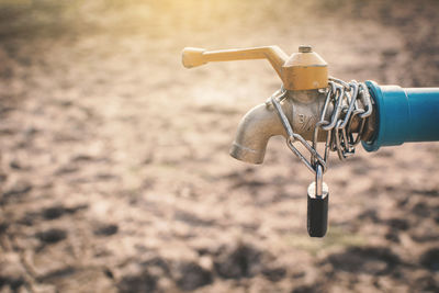 Close-up of padlock hanging on faucet