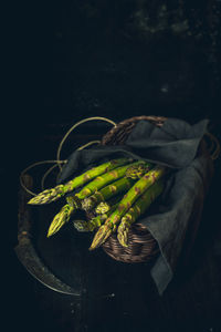 High angle view of vegetables in basket on table against black background