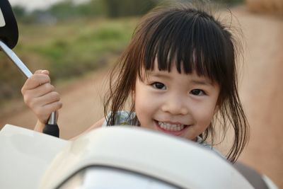 Close-up portrait of cute girl holding camera
