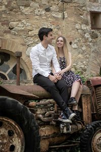 Friends using mobile phone while sitting on field