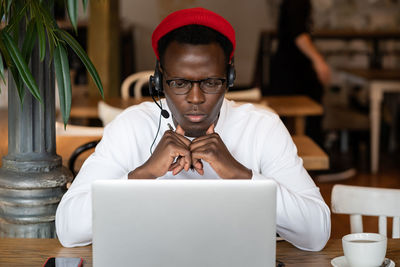 Midsection of man using mobile phone while sitting on table