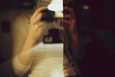 Double exposure of illuminated lamp and woman holding vintage camera