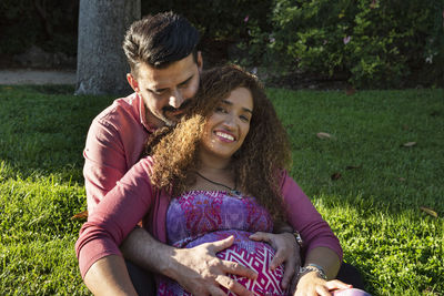 Happy young couple sitting on grass