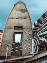 Low angle view of old abandoned building against sky