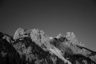 Low angle view of snowcapped mountains against clear sky