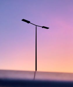 Low angle view of street light against sky at sunset