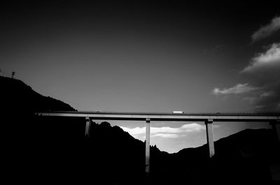 Low angle view of silhouette bridge against sky