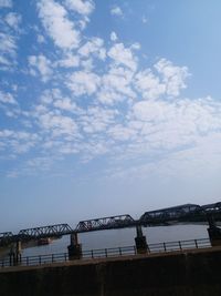 Low angle view of bridge over river against sky