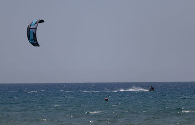 People in sea against clear sky