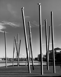 Low angle view of windmills on field