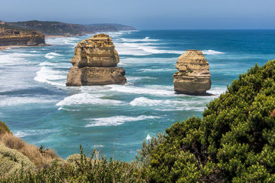 Scenic view of rocks in sea against sky