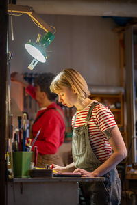 Rear view of woman holding illuminated christmas tree