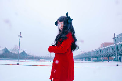 Young woman standing on snow covered field during winter