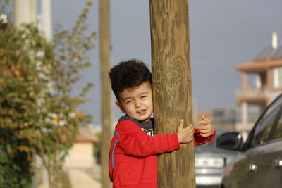 Portrait of boy standing by car