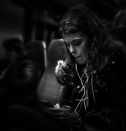 Young woman looking down while sitting outdoors