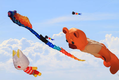 Low angle view of kites flying in sky