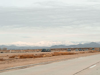 Road by desert against sky