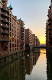 Reflection of buildings in river against sky