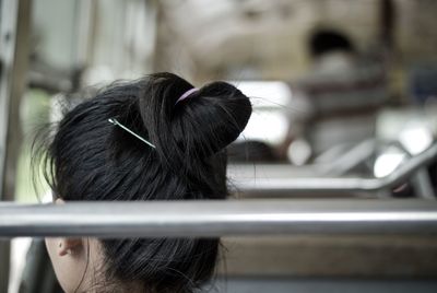 Rear view of woman with hair bun traveling in bus