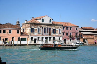 Houses by sea against clear blue sky