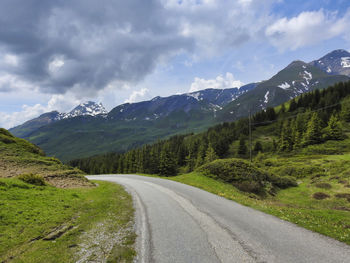 Road by mountains against sky