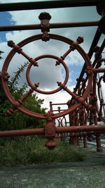 Close-up of rusty metal hanging against sky