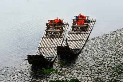 Photo of two traditional chinese style bamboo rafts moored on the shore