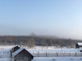 Scenic view of snow covered field against sky