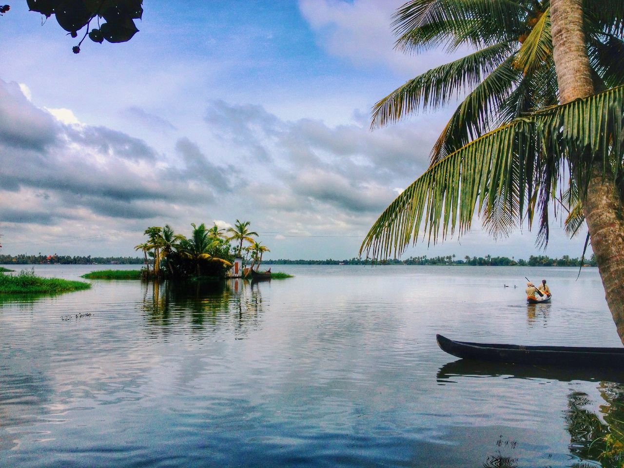 water, sky, tree, cloud - sky, palm tree, tranquility, tranquil scene, sea, cloud, scenics, nature, lake, beauty in nature, nautical vessel, waterfront, transportation, boat, cloudy, reflection