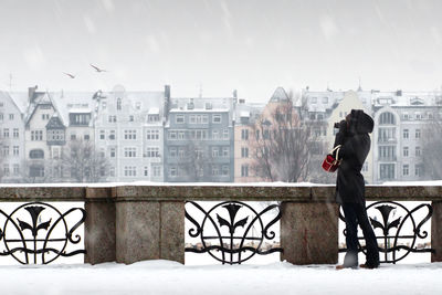 Woman standing in front of snow covered city