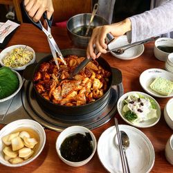 Midsection of woman having cooked cuttlefish in container on table