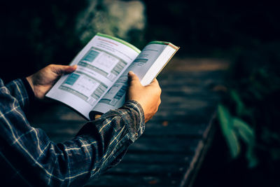 Midsection of person holding book
