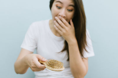 Midsection of woman holding apple against white background