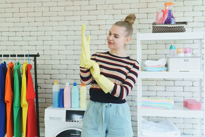 Full length of woman standing against multi colored wall