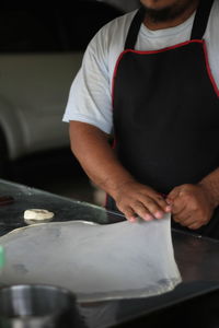 Midsection of man working in kitchen