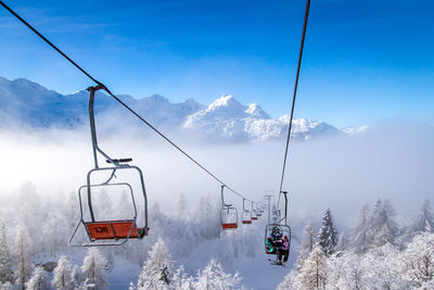 Overhead cable car on snowcapped mountains against sky