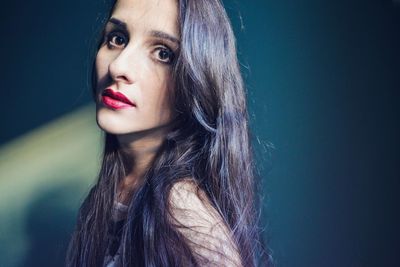Portrait of woman against blue background
