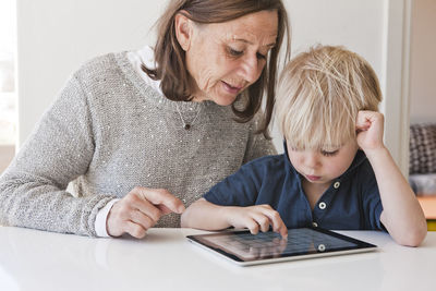 Grandmother with grandson using digital tablet