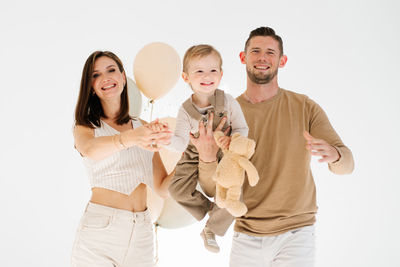 Portrait of smiling friends standing against white background