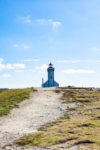Lighthouse by sea against sky