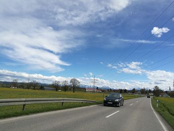 Cars on road against sky